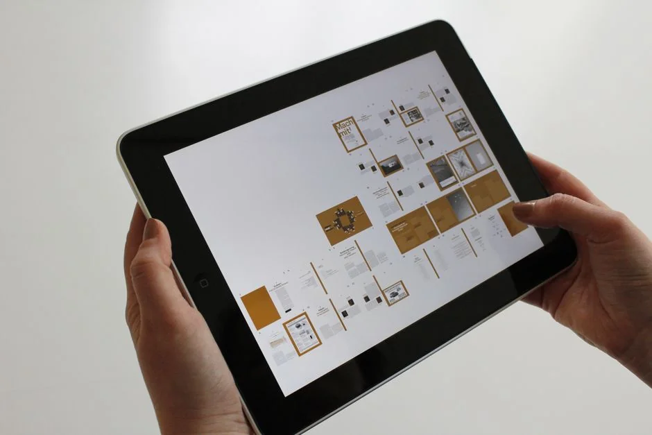 A tablet screen featuring images of minimalist decor emphasizing greenery and simple design.